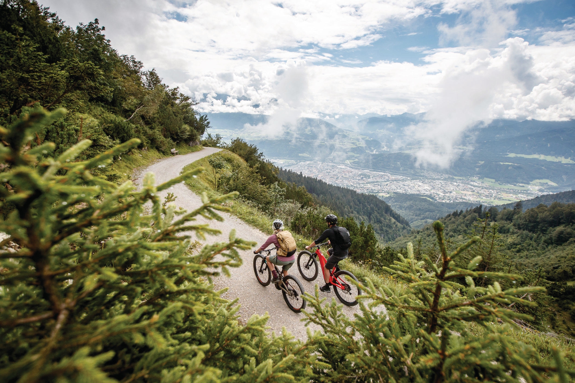 Due ciclisti su un sentiero di montagna con una vista pittoresca sulla valle.